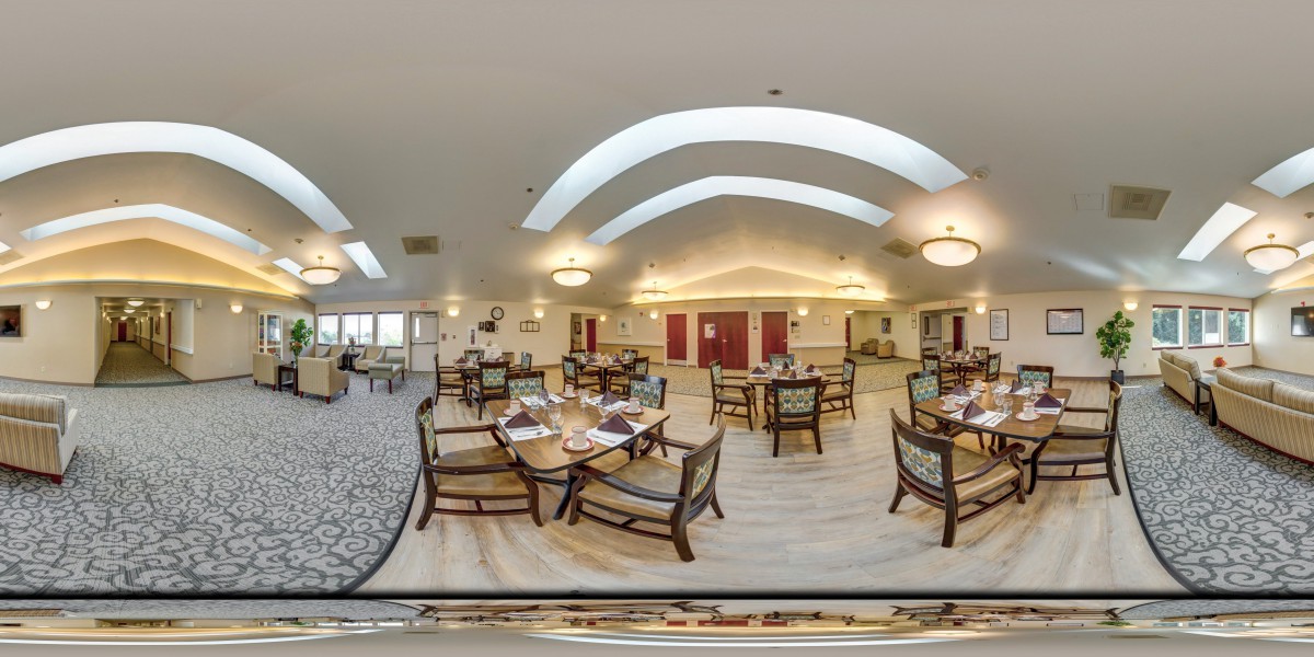 A spacious restaurant dining area with tables set for service, featuring elegant lighting and decor.