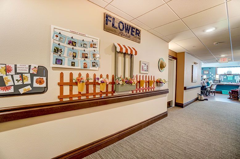 A hallway decorated with a flower theme, featuring a small fence and window display.