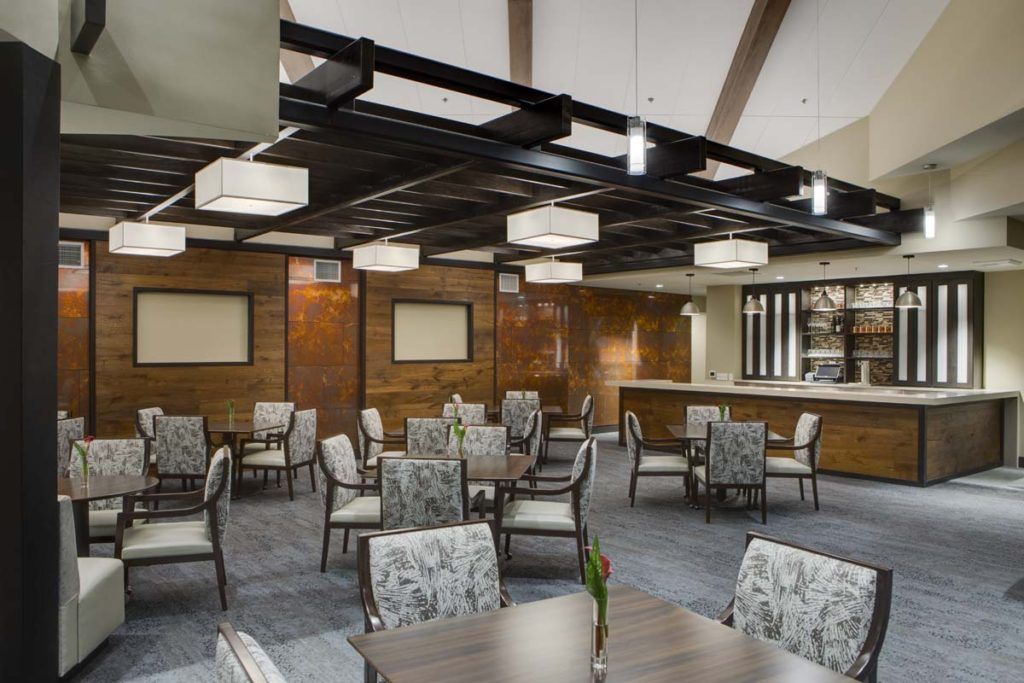 A modern restaurant interior with neatly arranged tables and chairs, featuring contemporary lighting.