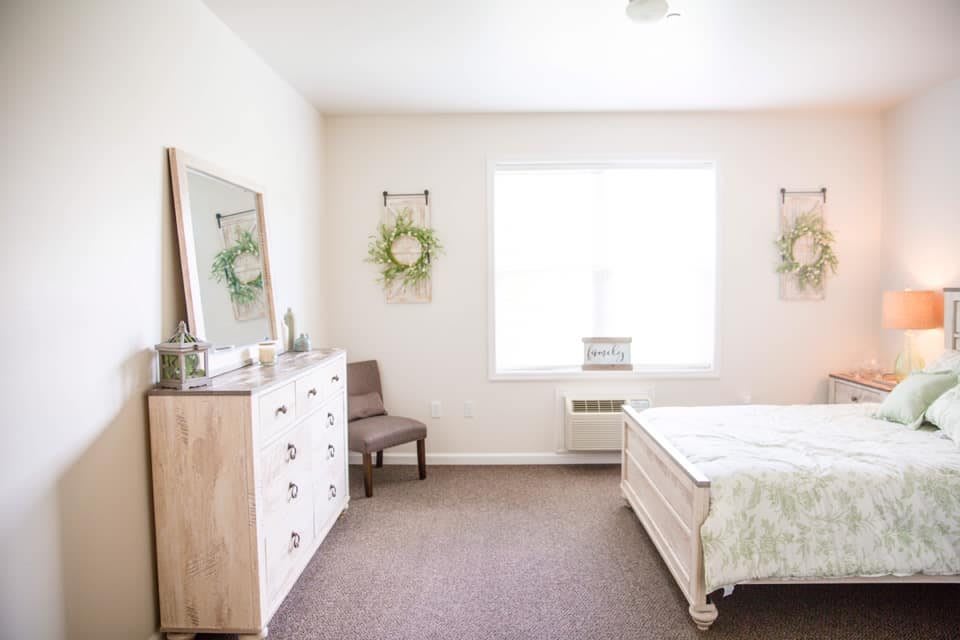 A minimalist bedroom with natural light and simple decor.