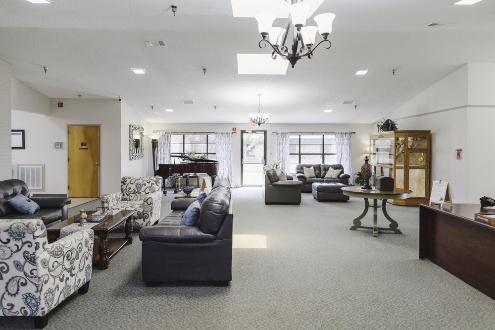 A spacious and elegantly decorated lounge area with comfortable seating, a grand piano, and ample natural light.