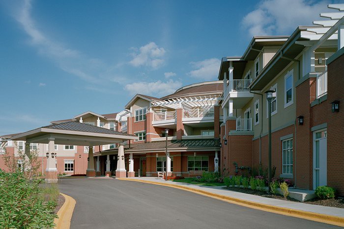 A modern senior living facility with multiple stories and a welcoming entrance.
