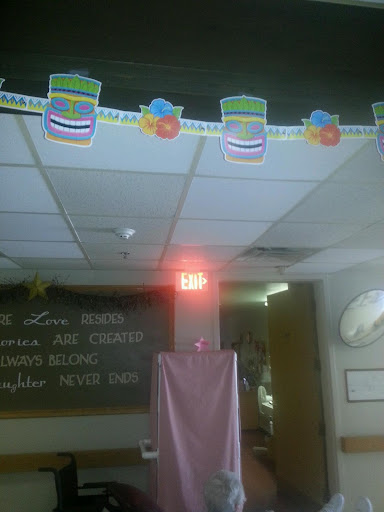 A festive celebration setup in a classroom with colorful decorations hanging from the ceiling.