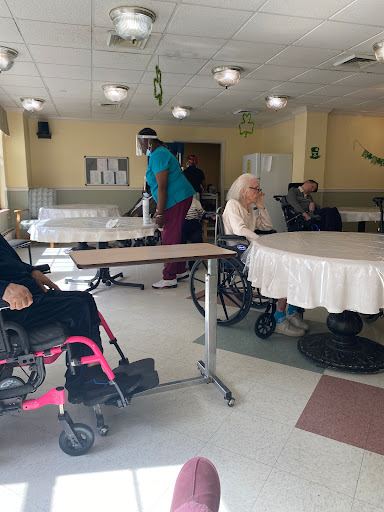 A glimpse into a nursing home where elderly residents are interacting with staff.