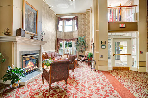 A cozy and elegant lobby featuring a fireplace, inviting seating, and warm decor.