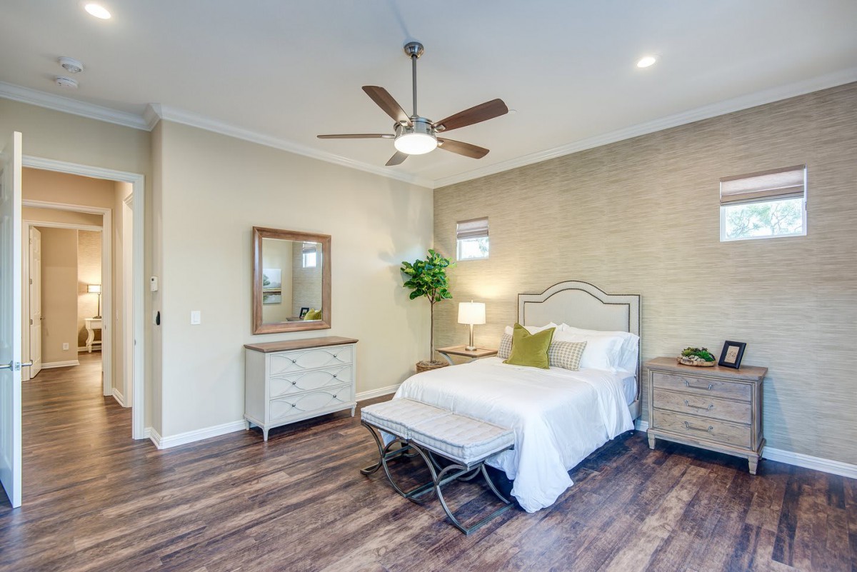 A modern bedroom with stylish furniture and wooden flooring.