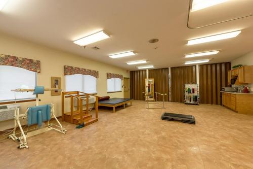A spacious physical therapy room equipped with various exercise tools for rehabilitation.