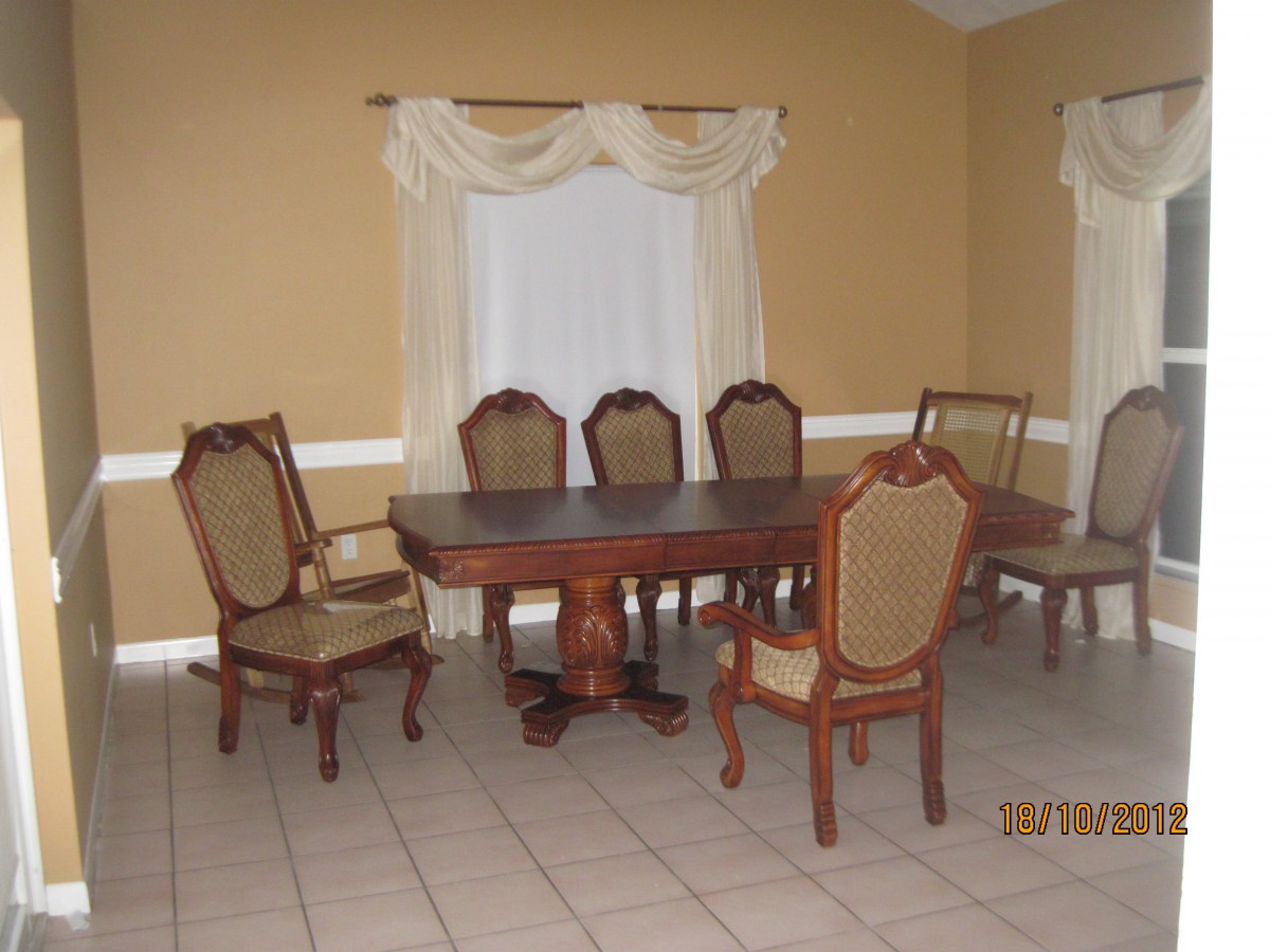 A classic dining room setup with a wooden table and upholstered chairs.