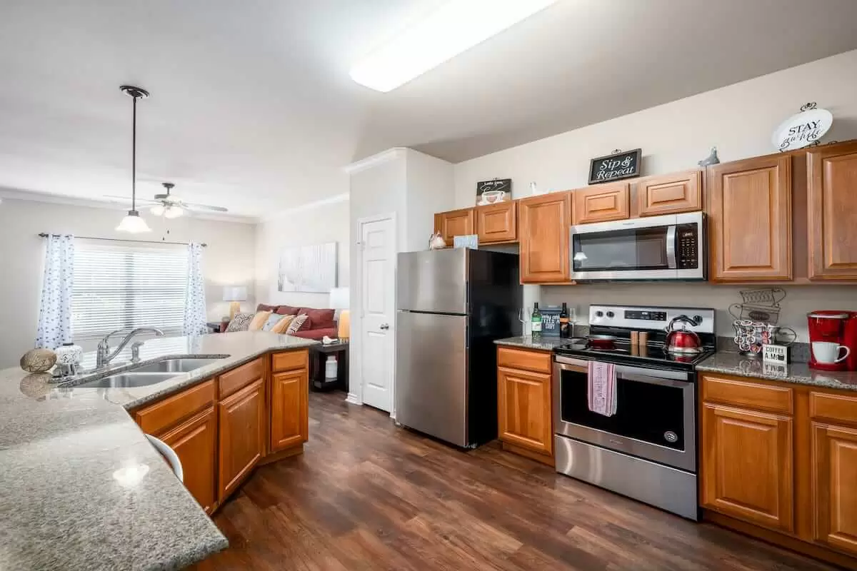 A modern kitchen featuring wooden cabinets and stainless steel appliances, with an open layout design.