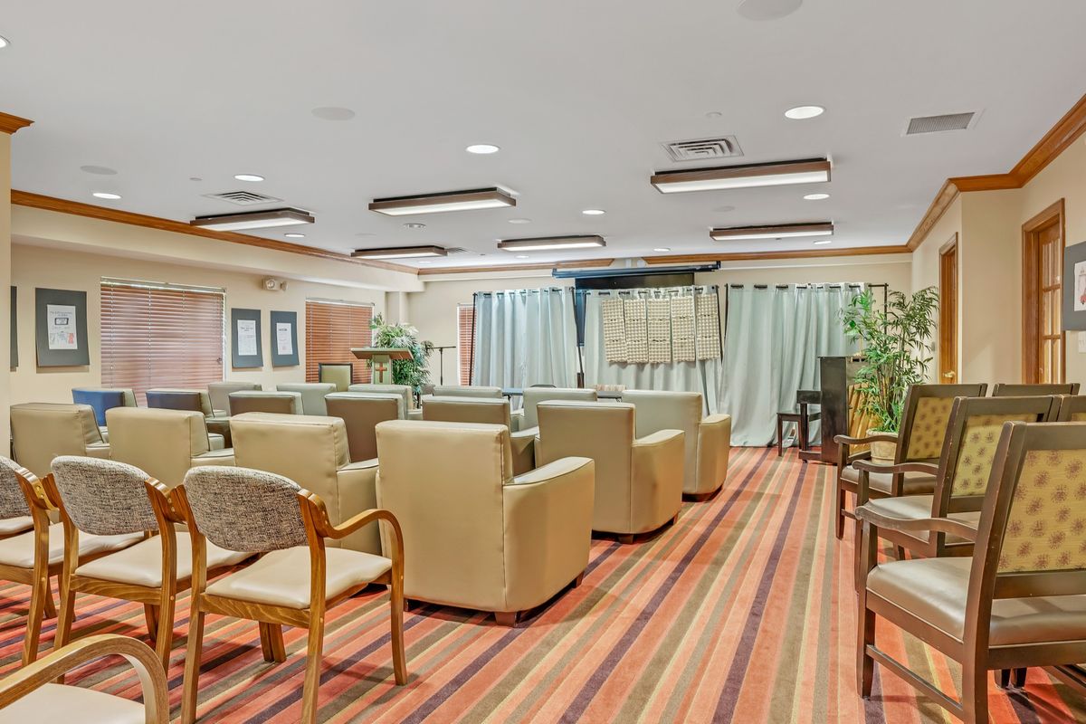 A spacious conference room with comfortable seating and striped carpet flooring.