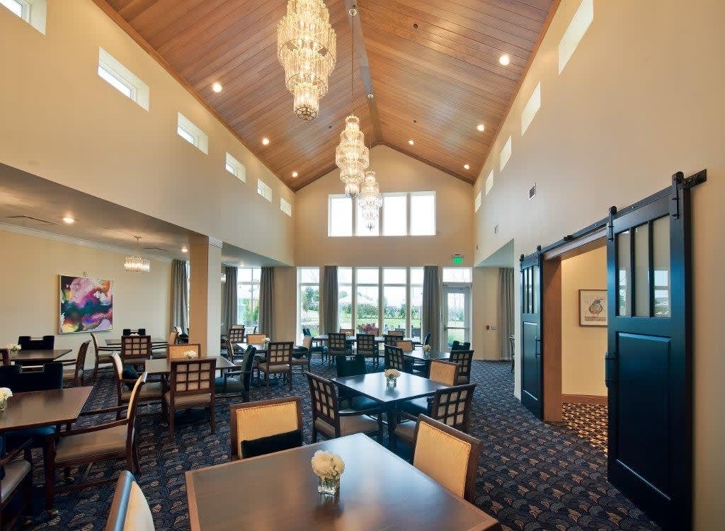 A spacious and modern dining area with elegant chandeliers and high ceilings.