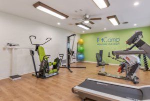 A modern gym facility equipped with various exercise machines including a treadmill and weight training equipment.