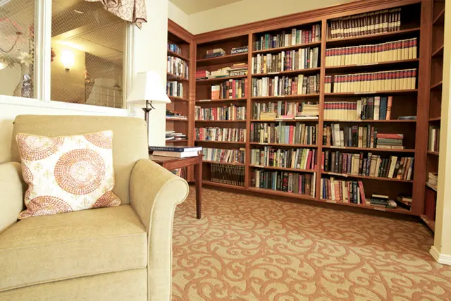 A cozy living room with a large bookshelf filled with books.