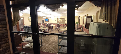 A view of a cozy dining area through glass doors, featuring well-arranged tables and chairs.