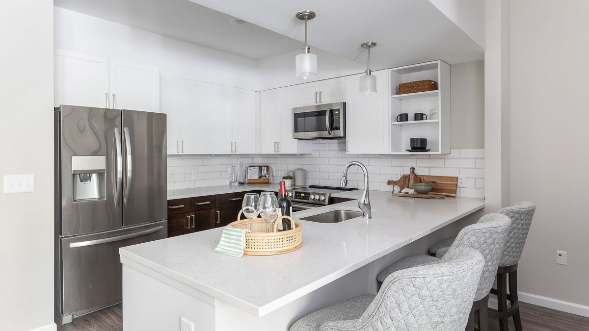 A modern kitchen with white cabinets and stainless steel appliances.