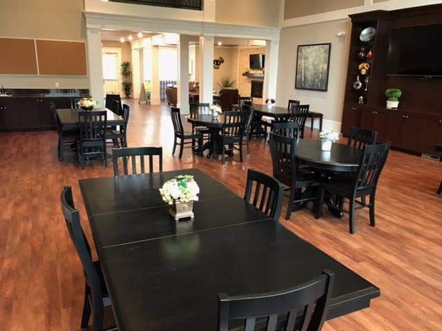 An inviting restaurant dining area with neatly arranged tables and chairs, featuring a wooden floor and decorative elements.