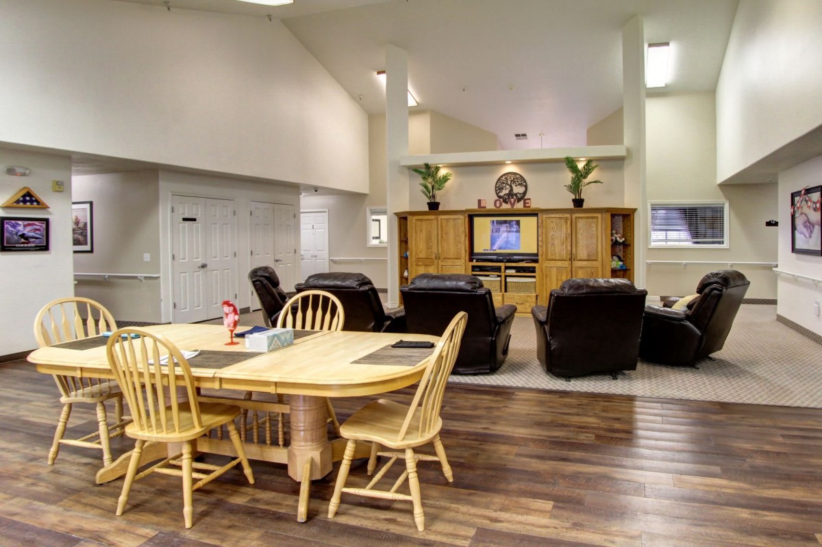 A spacious living room with a dining table, comfortable seating, and an entertainment center.