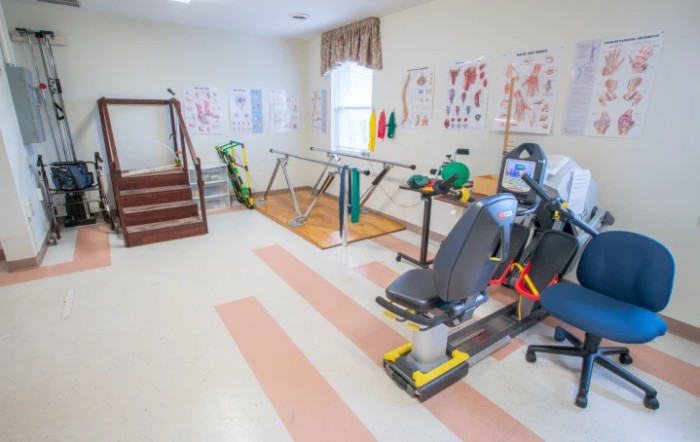 A physical therapy room equipped with exercise machines and rehabilitation tools.