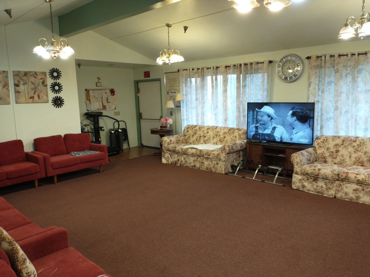 A cozy living room with various seating options, a television, and homey decor.