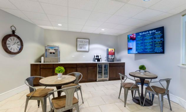 A modern break room with tables, chairs, and a beverage station.