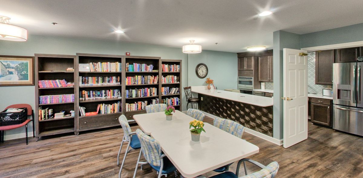 A cozy library with a dining area and bookshelves.