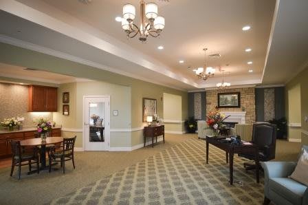 A spacious and well-lit living room with elegant furniture and chandeliers.
