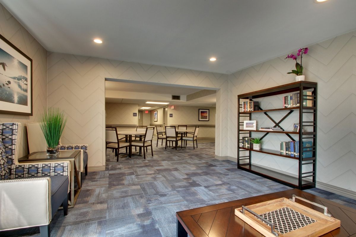 A modern lounge area with seating and a bookshelf.