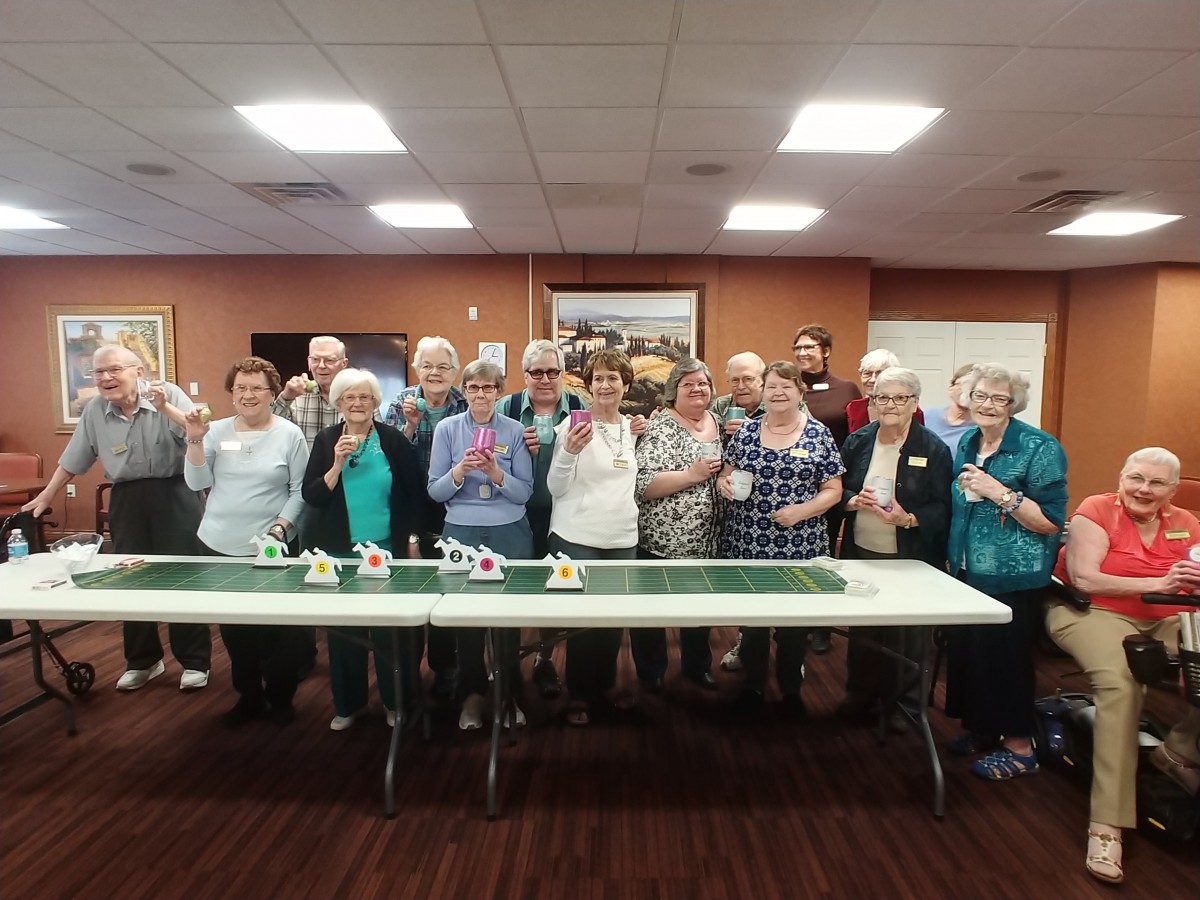 A group of seniors gathered indoors for a celebration.