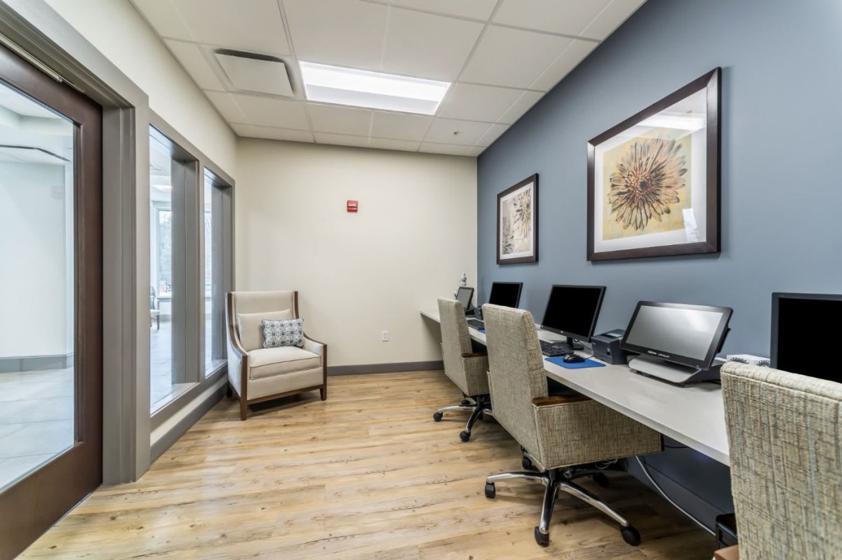A modern office workspace with computers and comfortable seating.