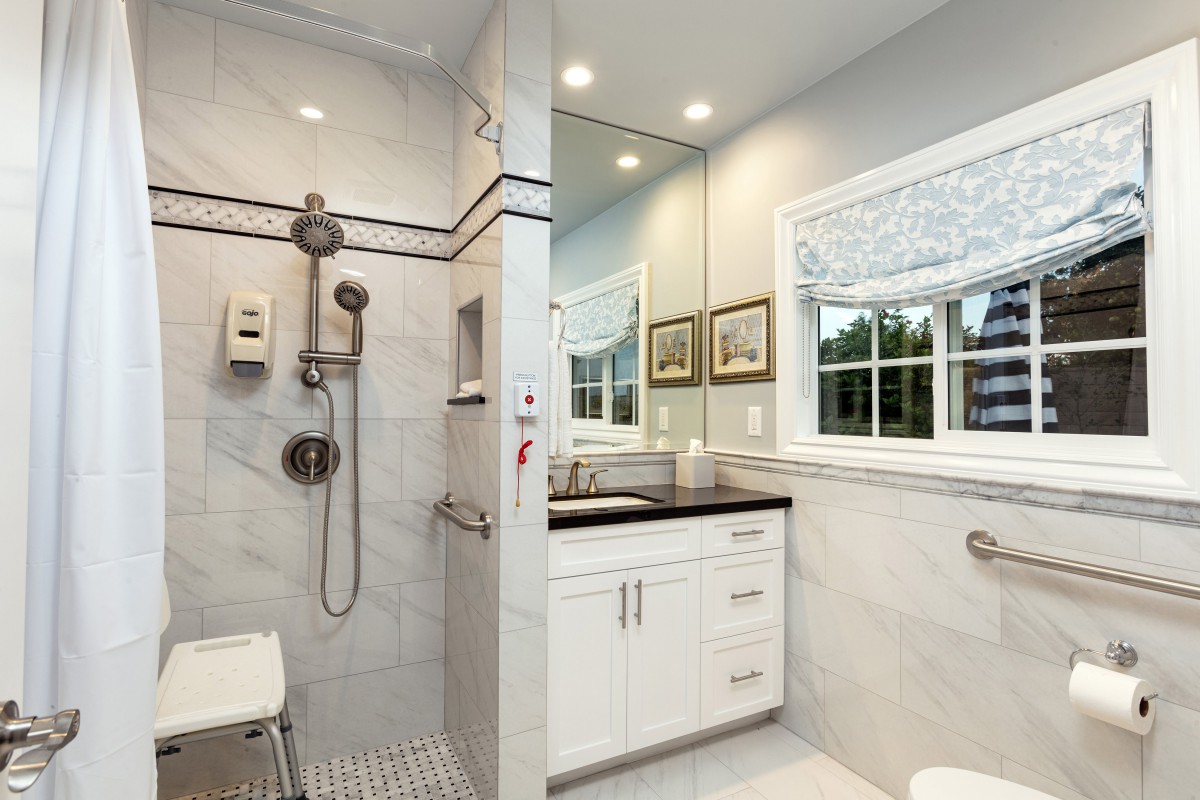 A modern bathroom featuring a walk-in shower and a stylish vanity with a large mirror.