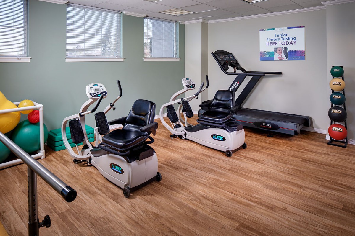 A fitness room equipped with a treadmill and stationary bikes.