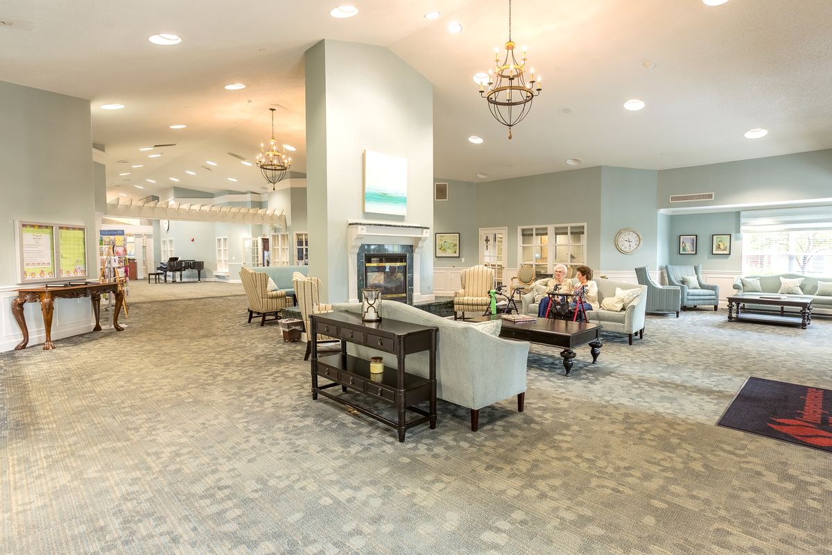 A luxurious and spacious lounge area with elegant chandeliers and comfortable seating.