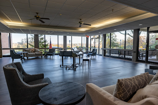 A bright and modern lounge area featuring comfortable seating and large windows that invite natural light.