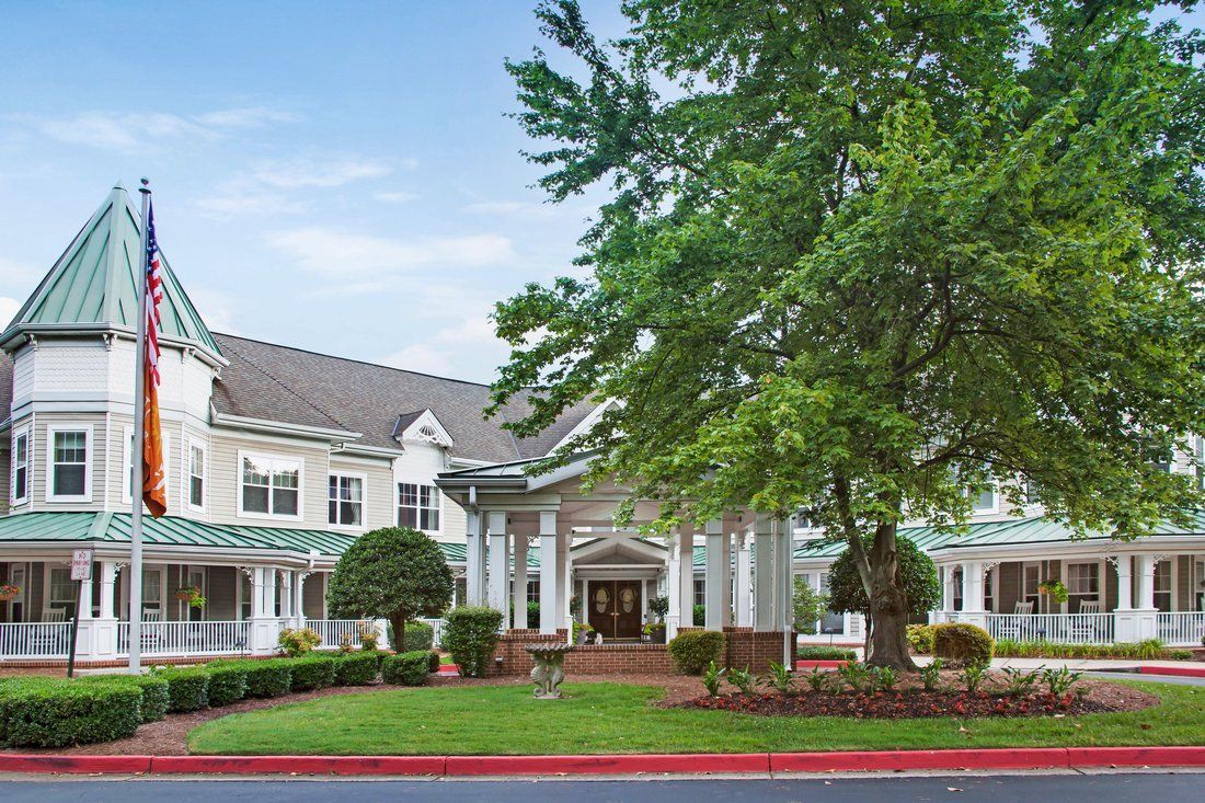 A well-maintained residential building with a landscaped entrance and lush trees.