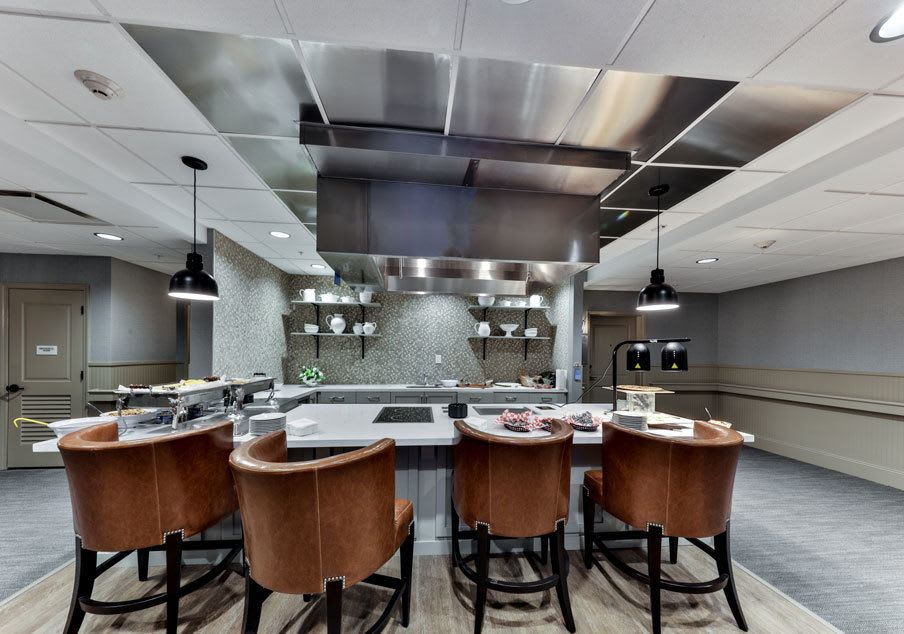 A modern kitchen with stainless steel accents and bar seating.