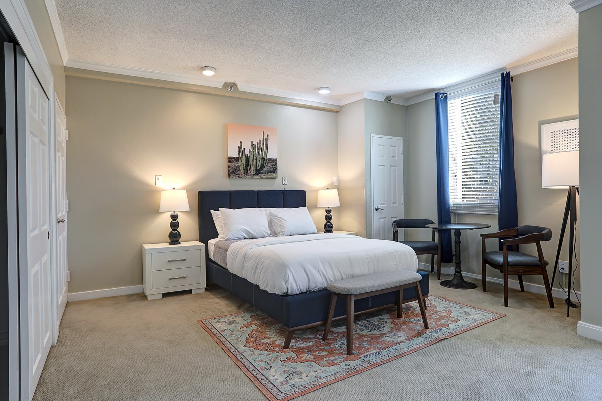 A modern bedroom with a comfy bed, nightstands, and elegant decor.