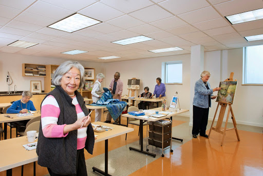 A lively gathering of senior citizens engaged in crafting activities at a community center.