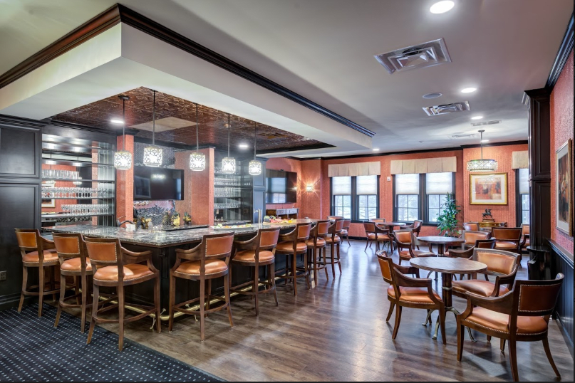 A cozy bar interior with wooden furniture and warm lighting.