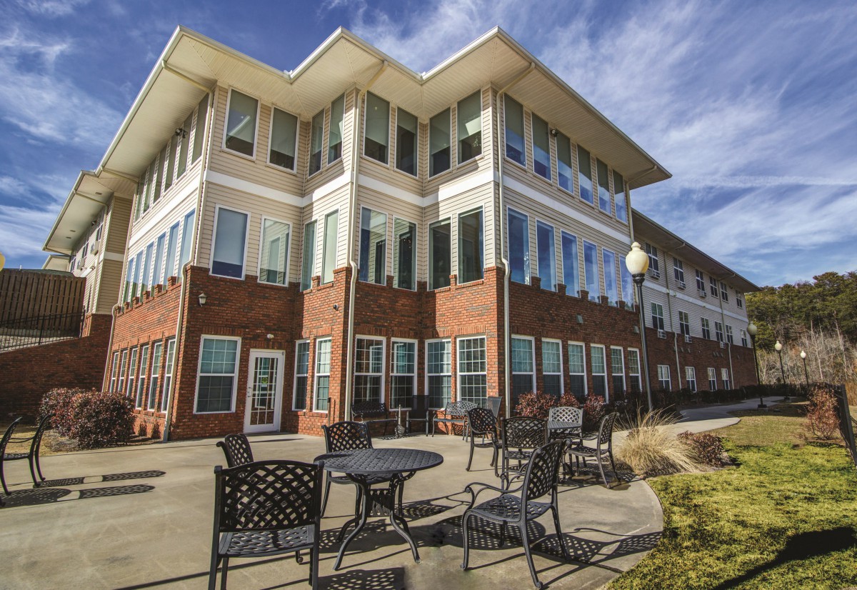 Modern building with outdoor seating and a bright blue sky.