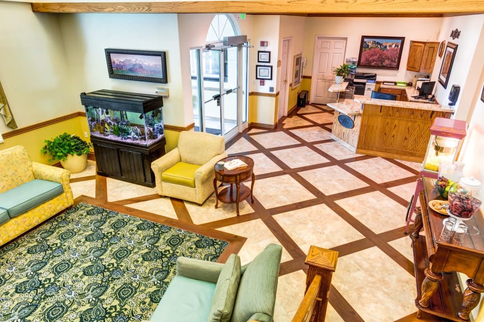 A bright and welcoming lobby with an aquarium, cozy seating area, and reception desk.