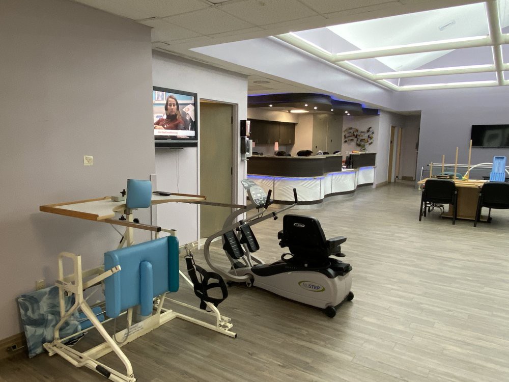 A modern rehabilitation center featuring exercise equipment and a reception area.