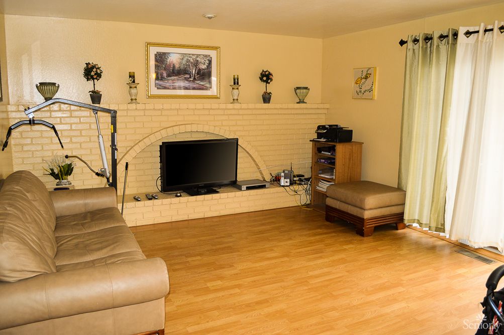 A cozy living room with a television and fireplace, featuring a comfortable couch and stylish decor.