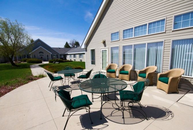 Outdoor patio area with tables and chairs on a sunny day.