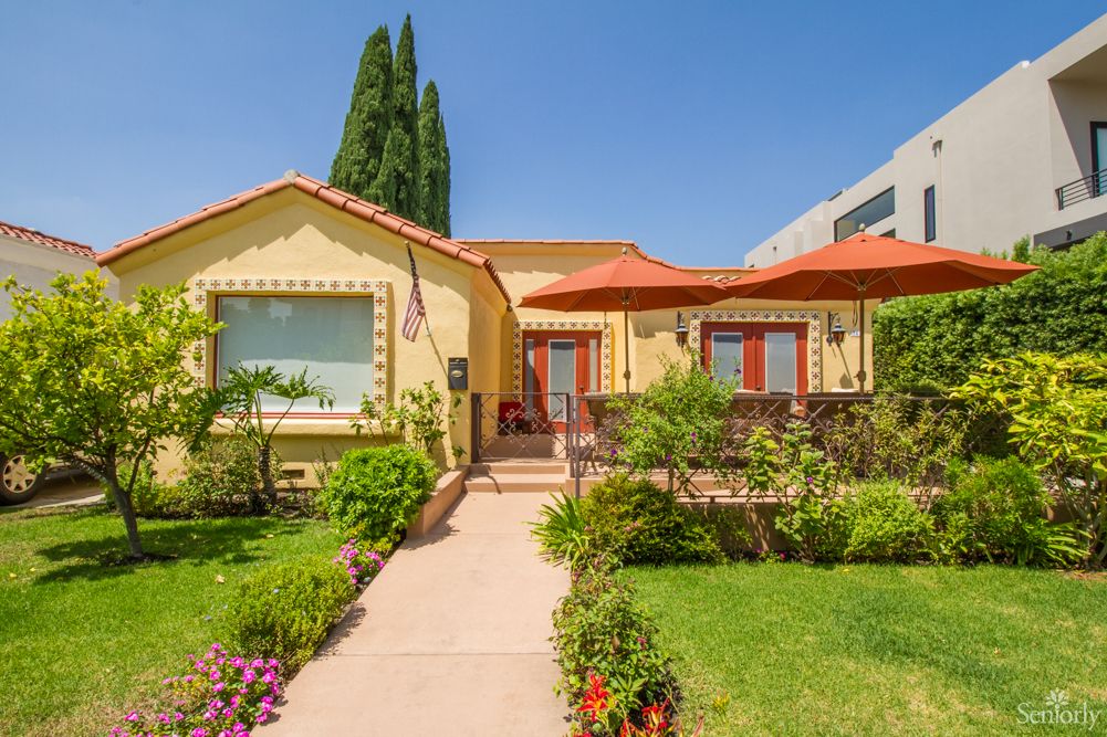 A charming single-story house with a well-maintained garden and vibrant greenery.