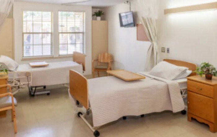 A hospital room with two beds and medical equipment.