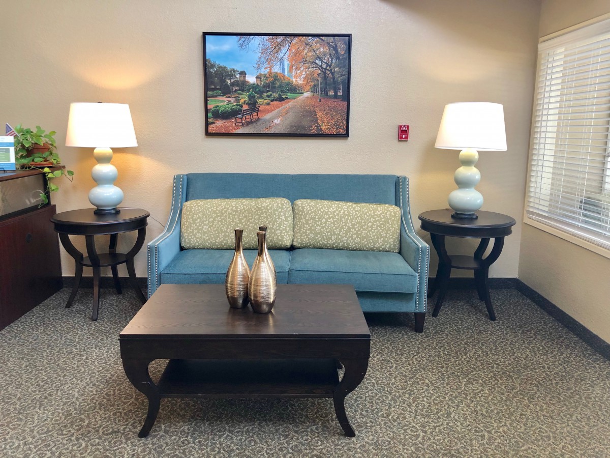 A cozy living room setup with a blue sofa, stylish table, and decorative lamps.