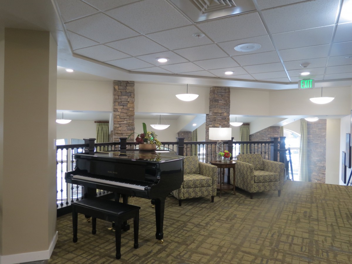 A spacious lobby area featuring a grand piano and comfortable seating arrangements.