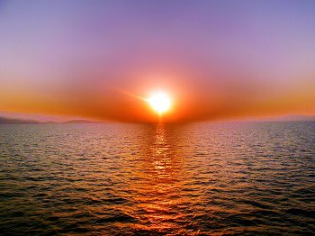 A beautiful sunset over the ocean with vibrant colors reflecting on the water.