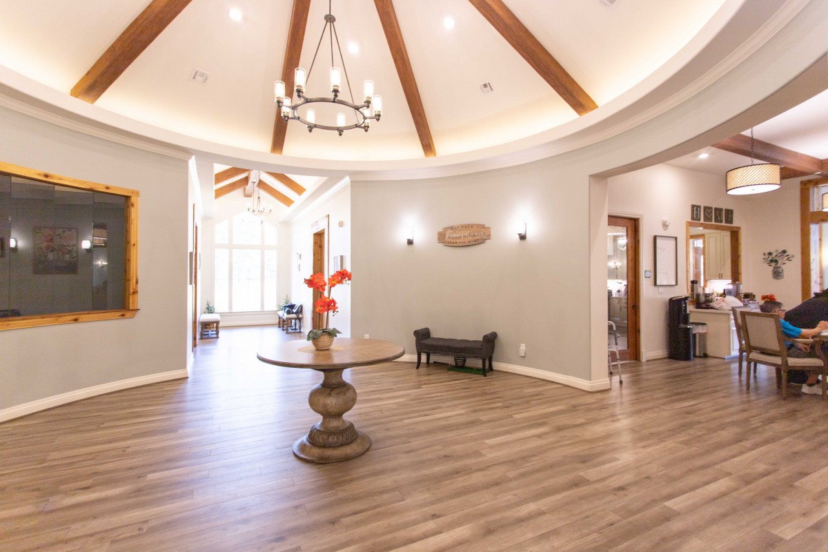 A spacious and elegantly designed lobby with a chandelier and wooden beams.