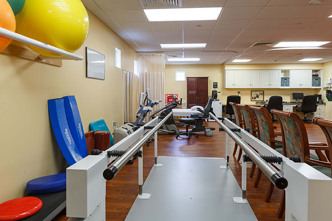 A rehabilitation center with various exercise equipment for physical therapy.